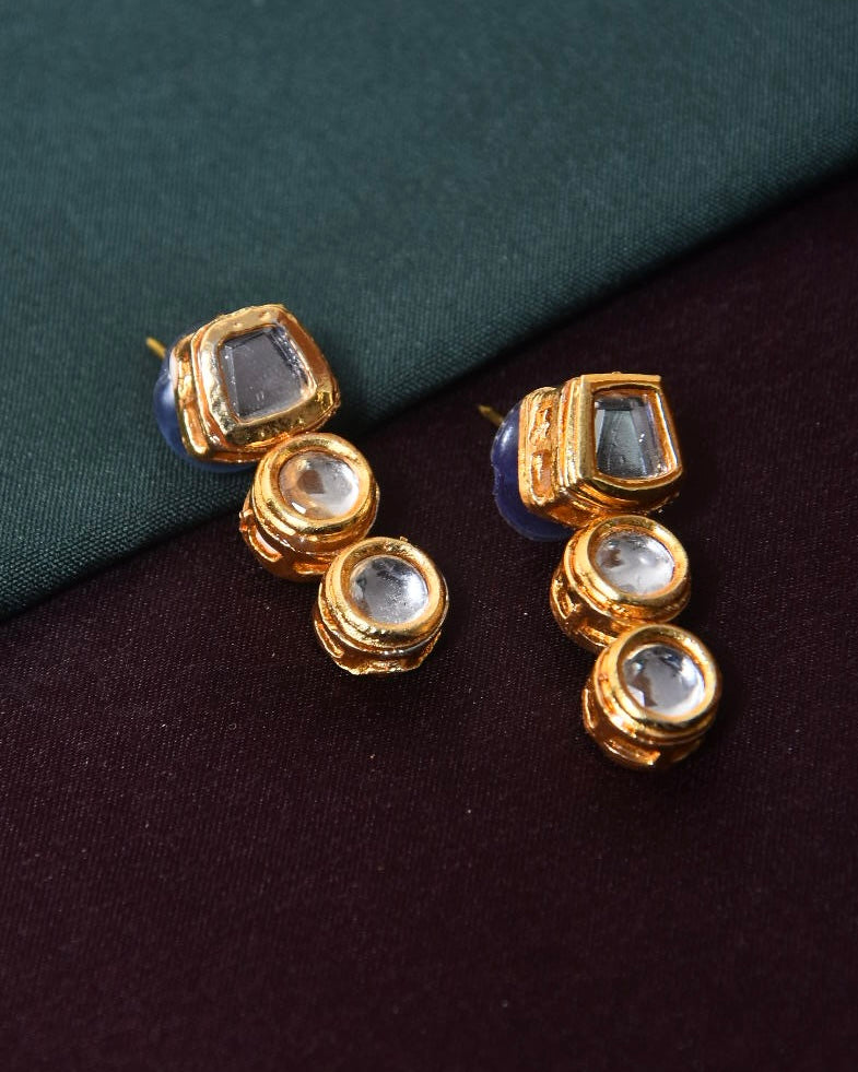 Gold and silver stud earrings with square and round gemstones.