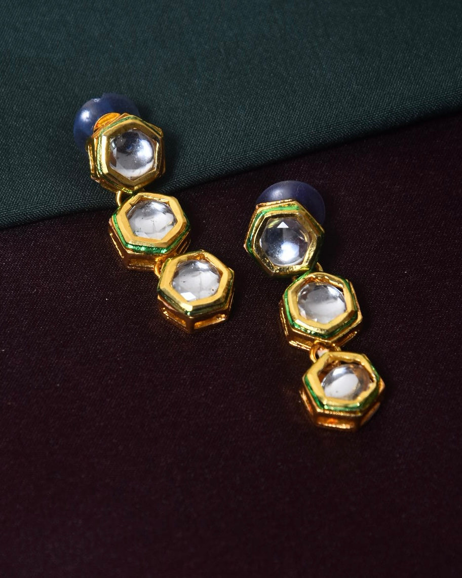 Gold hexagonal drop earrings with clear gemstones and blue accents.