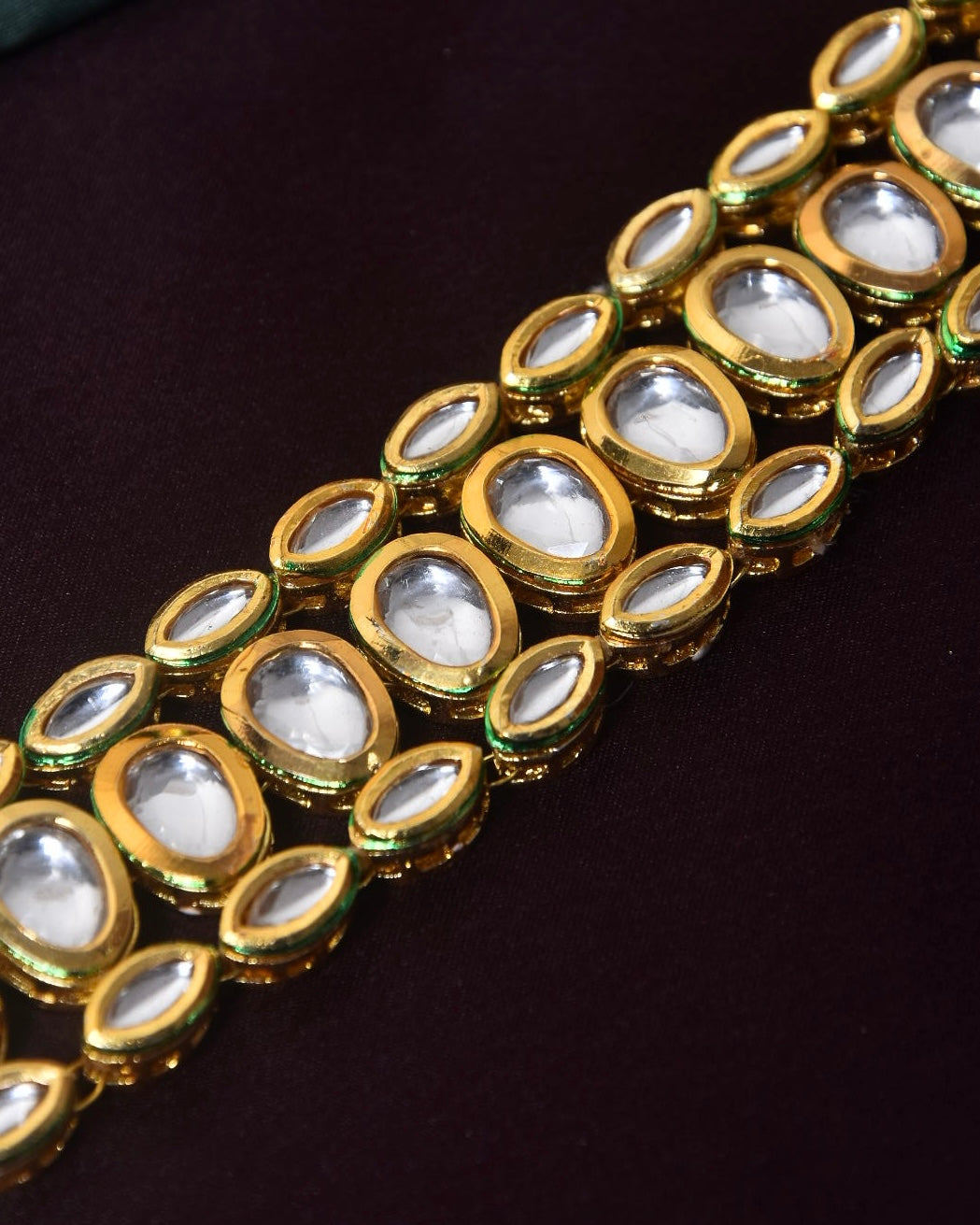 A gold bracelet with multiple oval-shaped white gemstones.