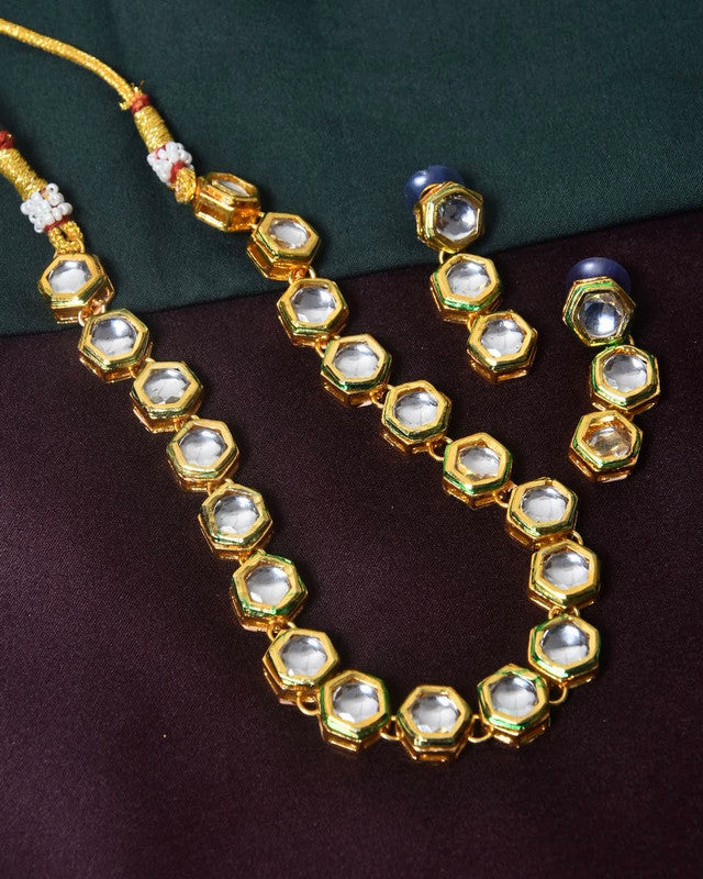 Gold necklace and earrings set with hexagonal crystal stones.