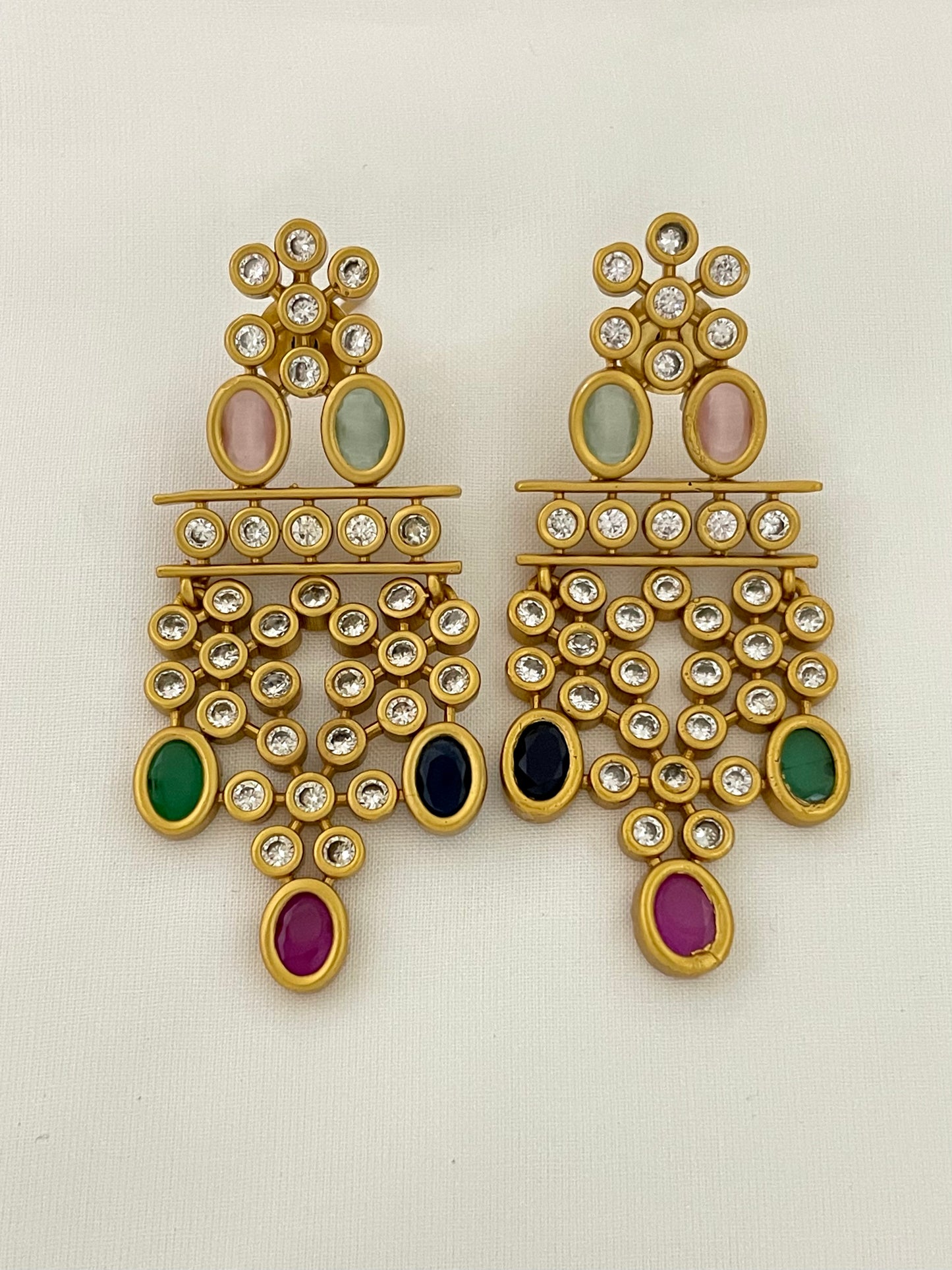 A pair of gold chandelier earrings adorned with multicolored gemstones and small white crystals.