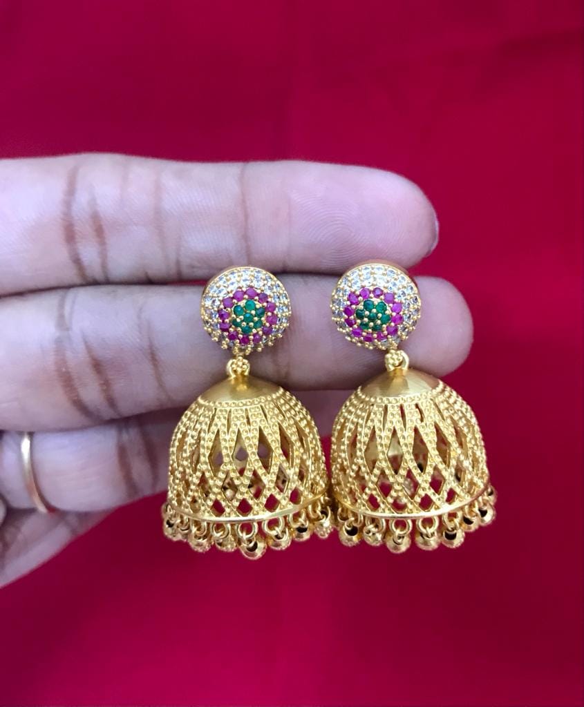 Gold jhumka earrings with intricate lattice design and multicolored stone accents.