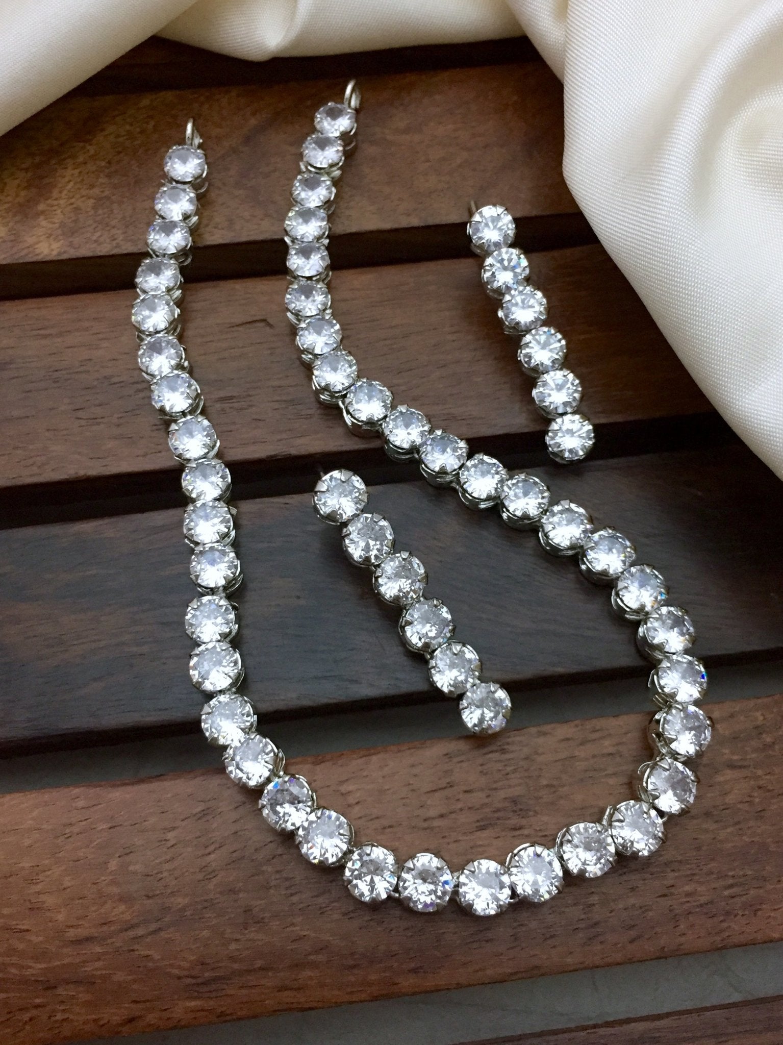 A necklace set with large, round, clear stones and a matching pair of earrings.