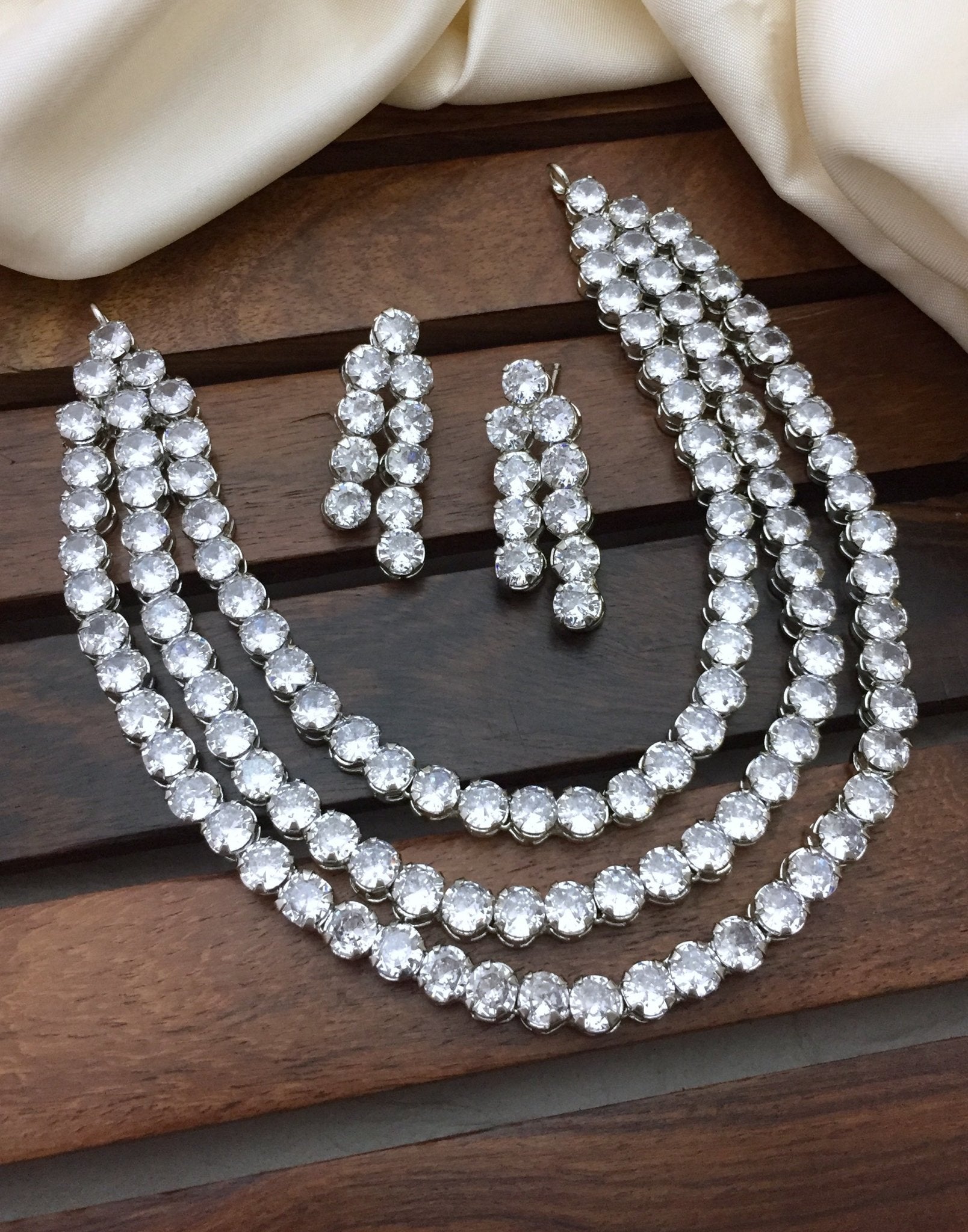 A necklace set with three rows of American diamonds and a matching pair of earrings.