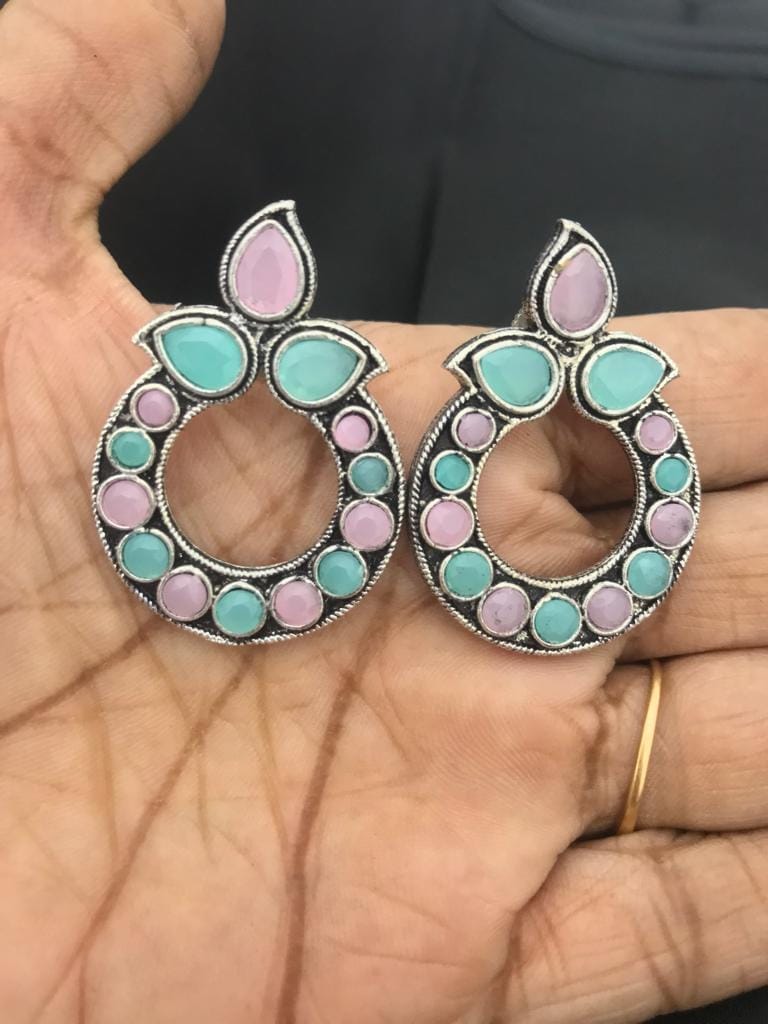 Light pink and mint oxidized earrings with circular design and teardrop-shaped accents.