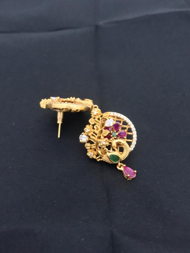 Gold stud earring with a matte finish, featuring ruby and emerald gemstones, and intricate design details.