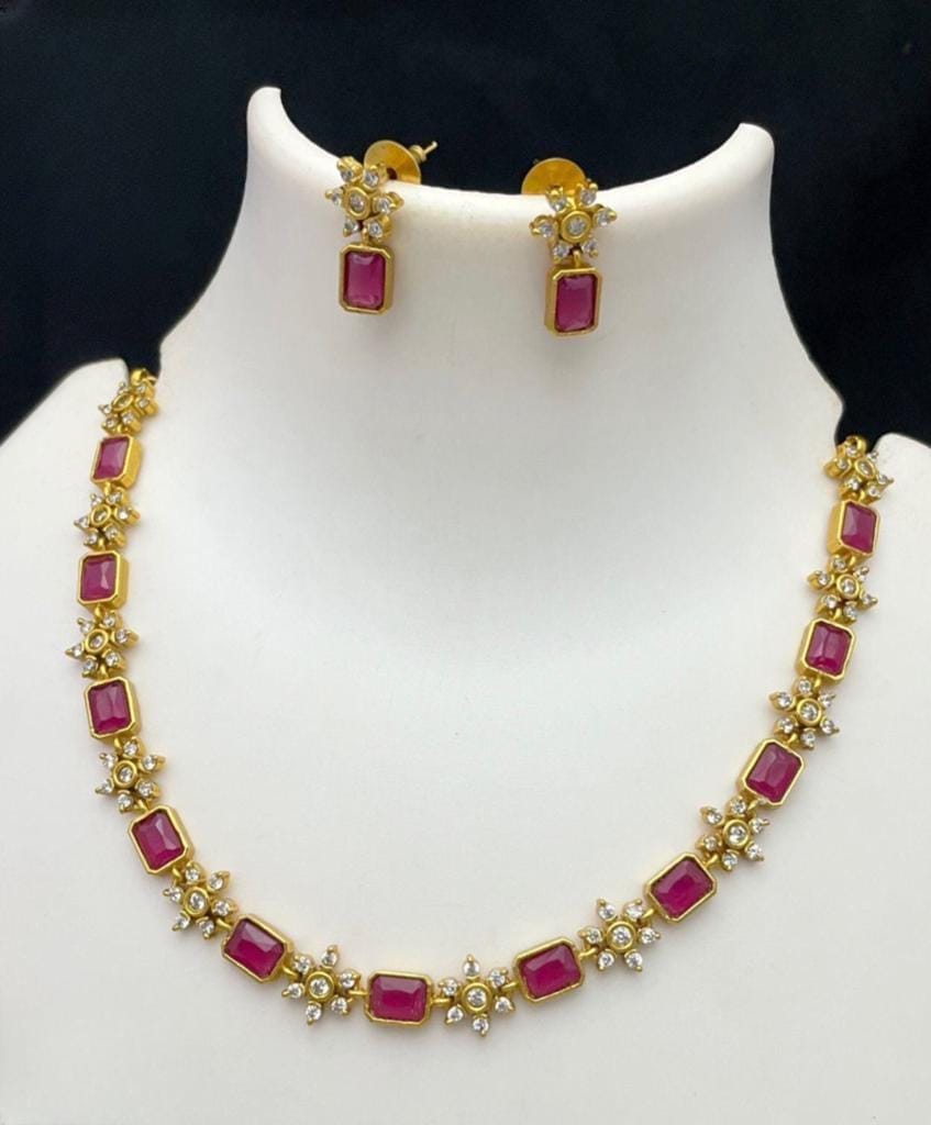 A handcrafted necklace with a matte finish featuring rich red rectangular stones and matching earrings.