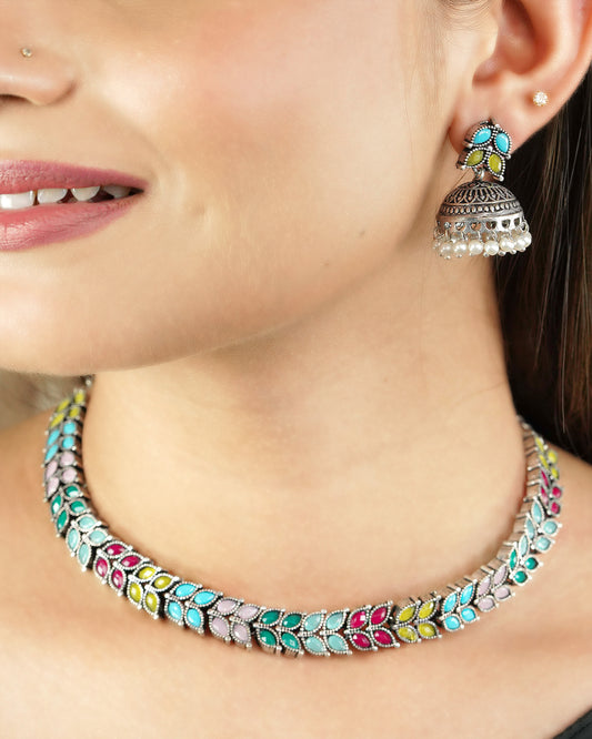 A woman wearing a colorful beaded necklace and a matching earring.