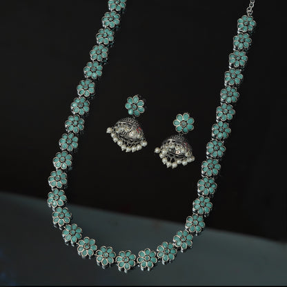 A silver necklace and matching earrings with turquoise flower designs.