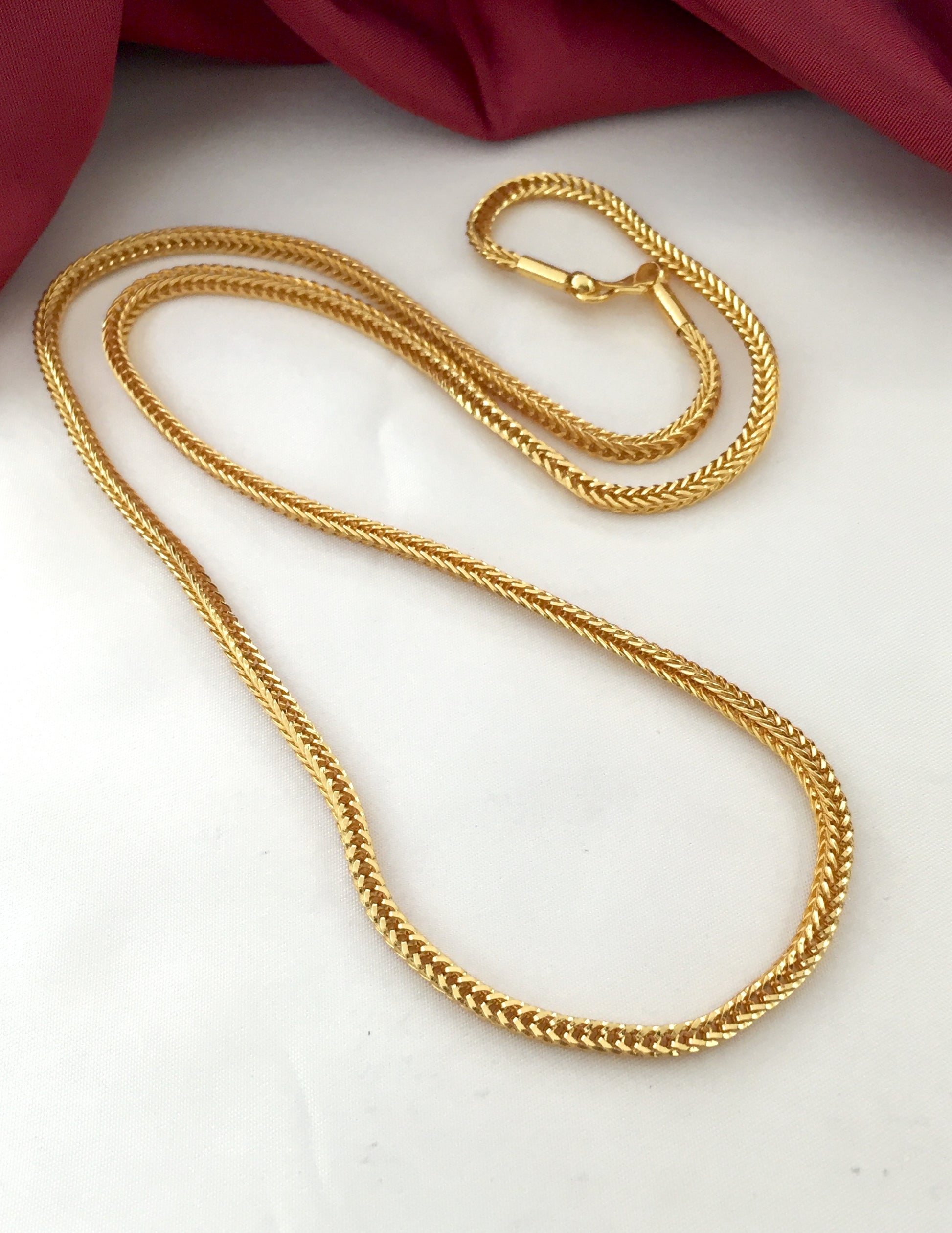 A gold chain necklace with a lobster clasp.