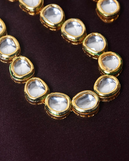 A gold necklace with clear, oval-shaped gemstones.