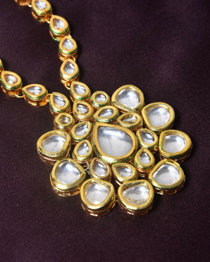 A gold necklace with a large pendant featuring multiple teardrop-shaped and oval white gemstones.