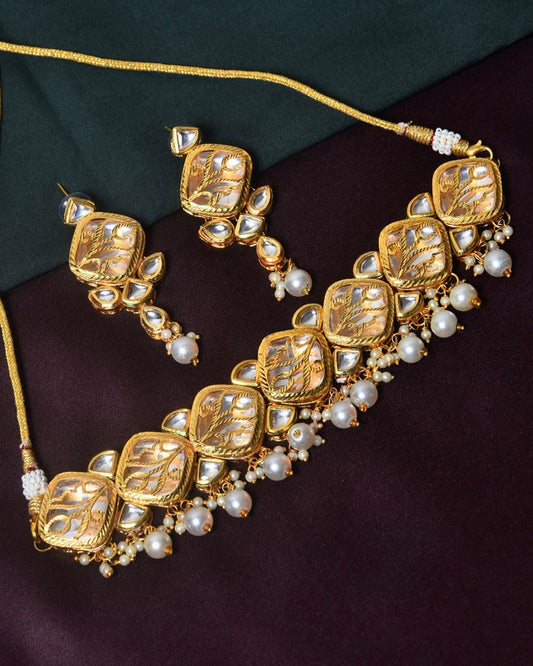 Gold necklace and earrings set with intricate designs, adorned with pearls and gemstones.
