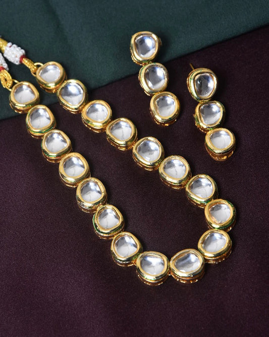 A gold necklace with large, clear, teardrop-shaped gemstones.