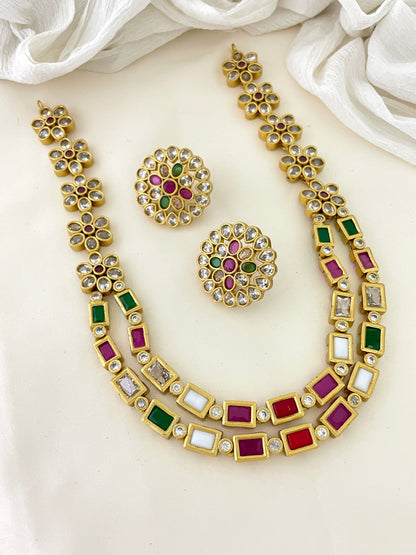 Gold necklace and earrings set with multicolored gemstones.