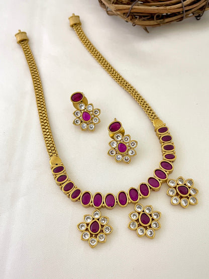 Gold necklace with red stones and matching earrings.