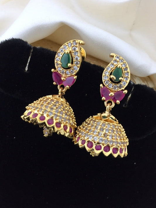 Gold jhumka earrings with multicolored stones, featuring a teardrop design with green and red stones and intricate detailing.