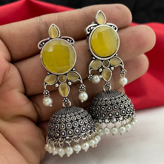 A pair of designer premium plated jhumka earrings with intricate detailing, featuring yellow gemstones and pearl accents.