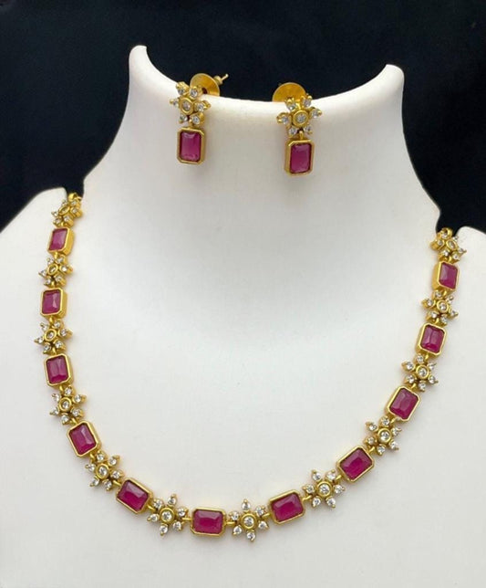 A handcrafted necklace with a matte finish featuring rich red rectangular stones and matching earrings.